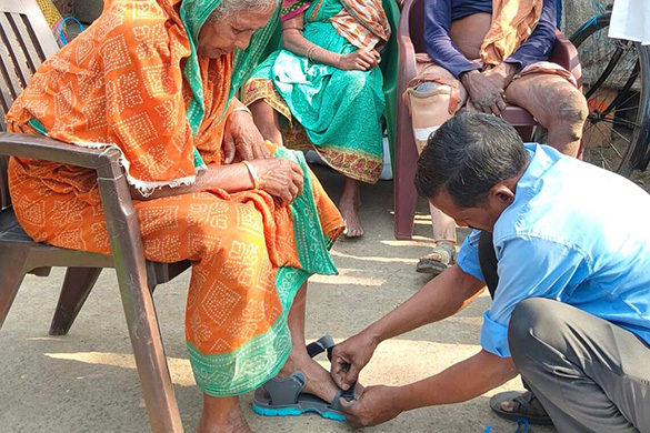 Fitting custom made sandals for a leprosy patient.